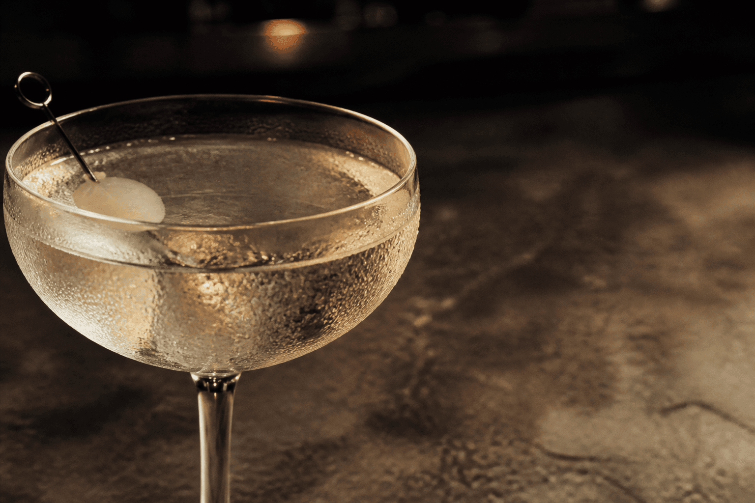 A chilled Gibson cocktail in warm bar light